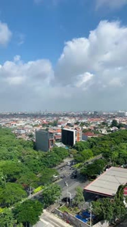 Timelapse de nuvens fofas se movendo sobre uma paisagem urbana verde