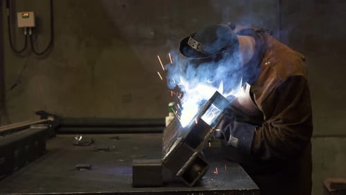 Nahaufnahme, Schmied, Schweißer mit Schutzmaske, arbeitet mit Metall, Stahl und Eisen durch Schweißen.
