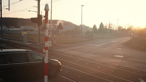 Carros cruzando trilhos de trem durante a hora dourada