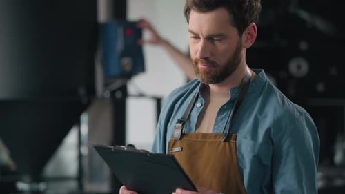 Männlicher Arbeiter Kaukasischer Mann Fachtechniker inspizieren Kaffeerösterei überprüfen Röstermaschine