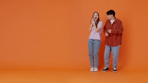 Une jeune femme montre une publicité pour un homme asiatique depuis le côté de la chambre