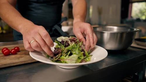 close-up The chef of an Italian restaurant decorates a dish he has prepared in a kitchen
