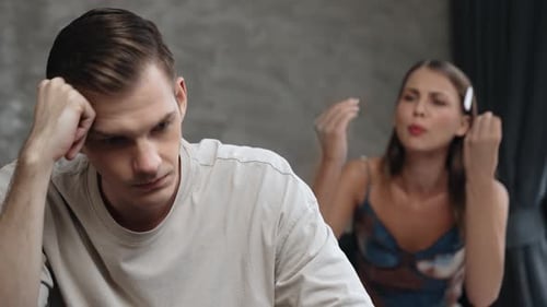 Frustrated Woman Arguing with Man in Gray Room