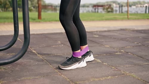 Close-up of Legs of a girl sports trainer performing exercises with an elastic band to strengthen