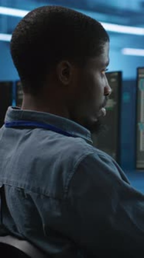 Vertical Video IT Specialist in Server Farm Ensuring Valuable Data Remains Shielded