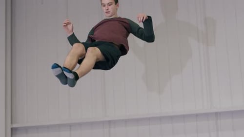 Young Adult Doing Gymnastics On Trampoline