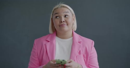 Woman Looking at Mobile Phone in Studio