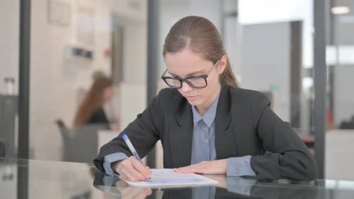 Businesswoman Doing Paperwork in Office