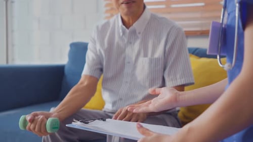 Senior Man Exercises with Dumbbell and Health Professional