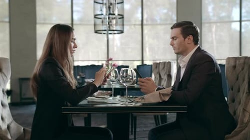 Business People Using Mobile Phone at Restaurant. Businessman and Businesswoman Working Smartphone