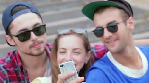Friends Looking at Cellphone Together Outside