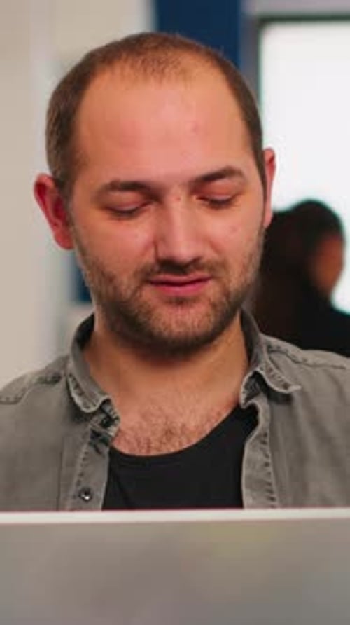 Young Man Using Laptop in Modern Office