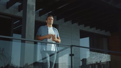 Man Enjoying Morning Coffee on Balcony