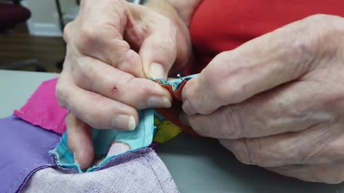 Older Woman Sewing close up of hands