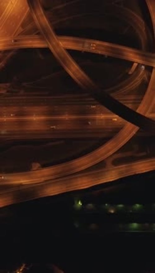 Vídeo vertical con vista aérea de una intersección de carreteras compleja iluminada