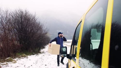 Delivery Man with Smartphone Delivering Parcel Box to Recipient