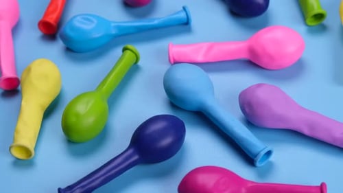 Rotating Multicolored Balloons on a Blue Background Top View the Concept of Celebrating a Birthday