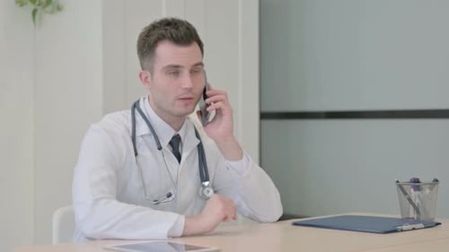 Young Doctor Talking on Phone in Clinic