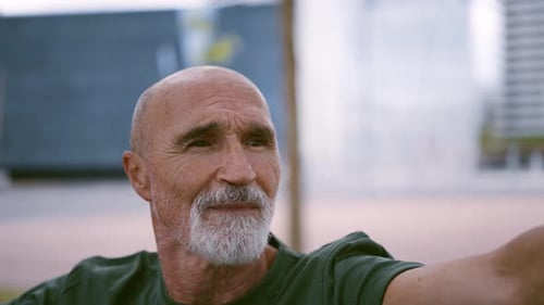 Senior Man Extends Arm Outdoors