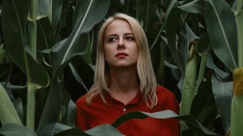 Woman in stylish orange color shirt in the middle of a cornfield, Poland