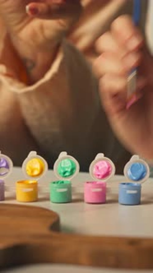 Brush Dipping into Pastel Paint Pots for Easter Egg Decoration