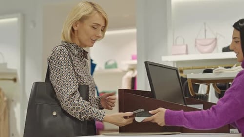 Blonde Woman Buying Clothes in Designer Boutique