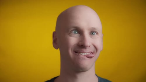 Man Making Silly Faces Against Yellow Background