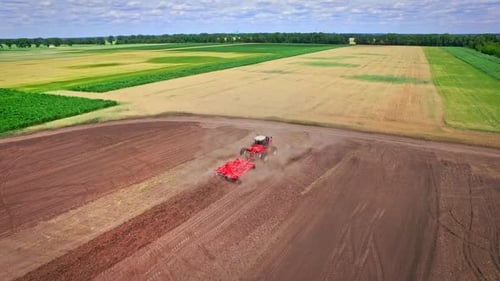 Agricultural Tractor Plowing Field. Agricultural Machinery Working on Rural Field. Agricultural Indu