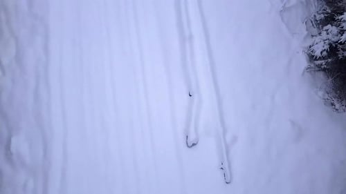 Winter Beauty. Aerial footage of drone taking off above the snow that's covering the forest road and