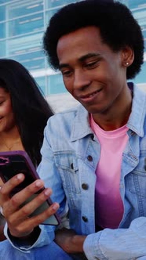 Friends Looking at Phone Together in Urban Setting