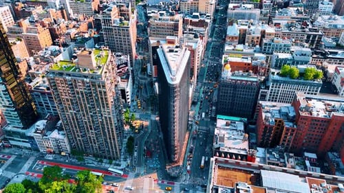 Flatiron Buildings standing between two busy streets of New York, USA.