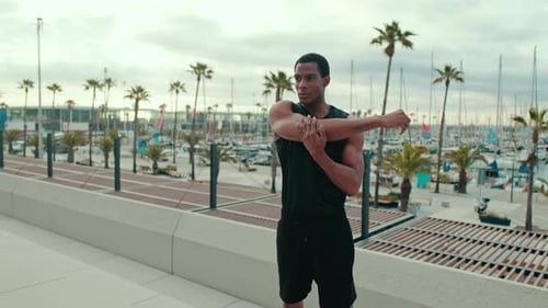 Young Man Stretching by the Marina