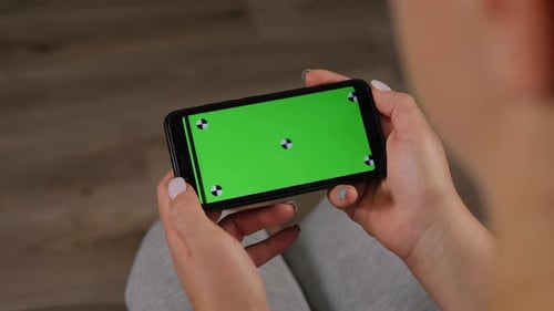 Closeup of a Young Woman Holding a Smartphone with a Green Screen Chromakey