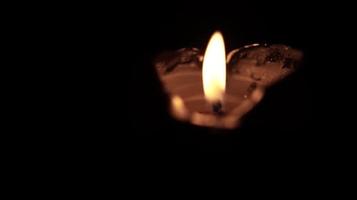 Single Candle Flame Flickering in Darkness