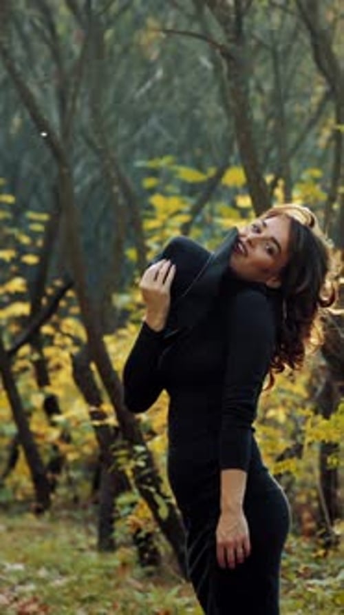 Woman relaxing in park. Happy attractive woman relaxing in sunny autumn park Vertical video