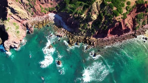 Topdown View Of Waves Crashing On The Rocky Shoreline And Cliffs. - aerial shot