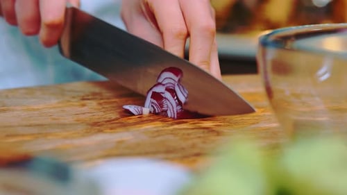 Hands Chopping Red Onion on Cutting Board