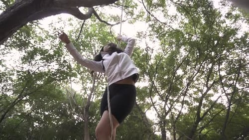 A sporty gymnast performs exercises with a rope in sportswear.Concept: power, strength, healthy life