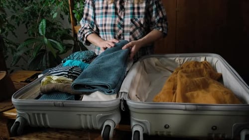 Woman Packing Clothes in Suitcase for Travel