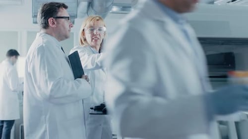 Dois pesquisadores programam equipamentos médicos com teclado de computador. Equipe de profissionais faz