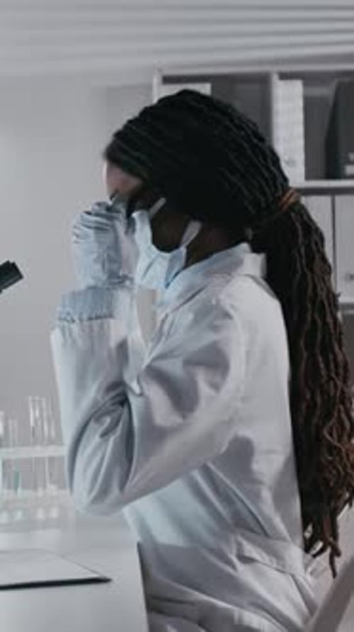 Female Scientist Working with Microscope in Lab