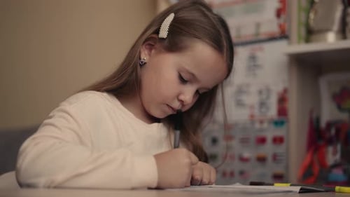 Young Girl Studying at Home Focused Elementary School Student Writing in Notebook