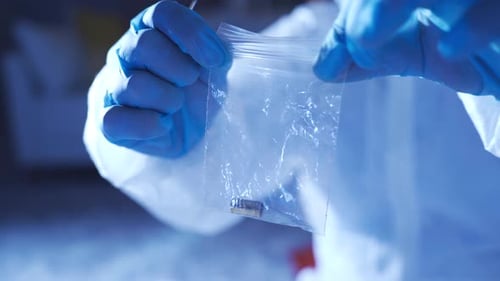 Placing Bullet Casing into Bag at Crime Scene