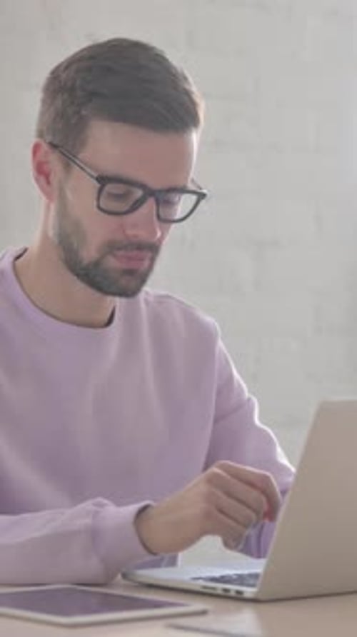 Man Working on Laptop at Desk Indoors