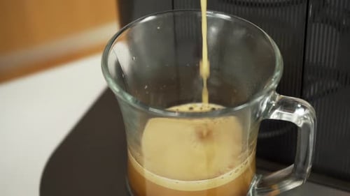 Coffee Poured from Coffee Machine into Glass Mug