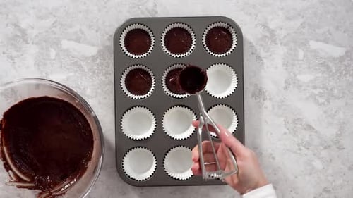 Time Lapse Flat Lay Scooping Chocolate Cupcake Dough Into the Cupcake Liners