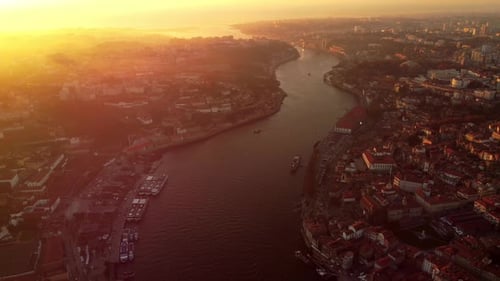 Aerial sunset cityscape of Porto Portugal, drone fly above Douro river revealing the main city cente