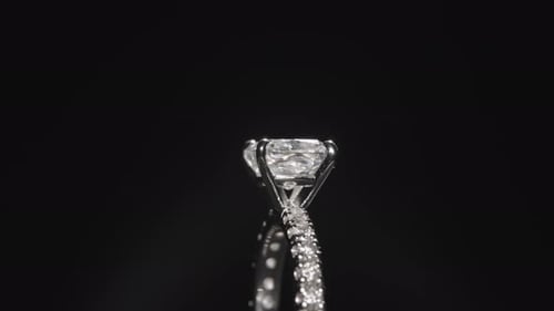 Luxuriöser Diamantring aus nächster Nähe, der sich vor einem schwarzen Studiohintergrund dreht
