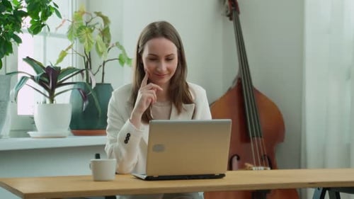 Schöne Geschäftsfrau, die an ihrem Laptop sitzt, hat eine brillante Idee, eine plötzliche Einsicht