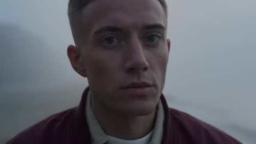 Attractive young man stares into the distance in fog